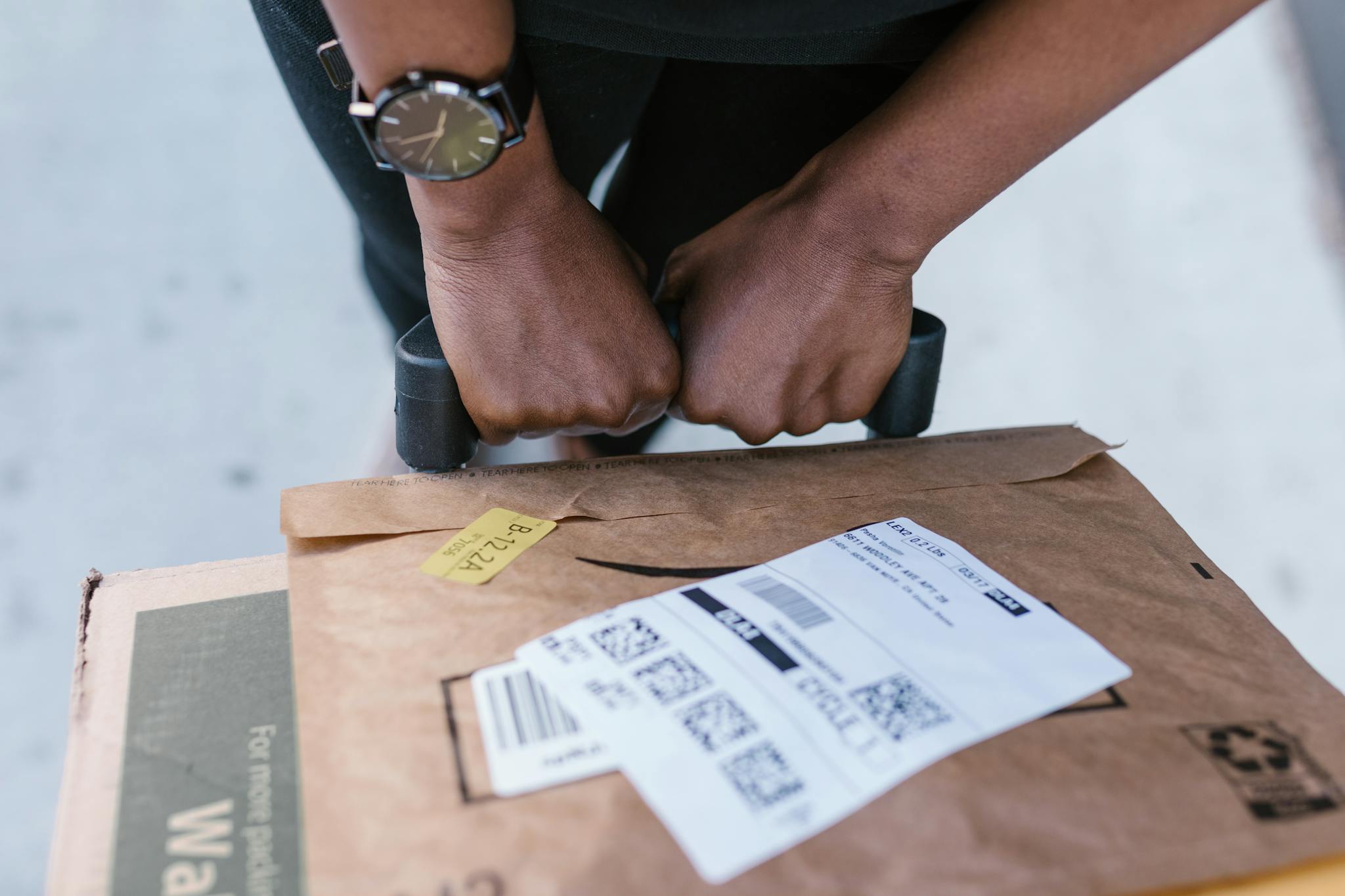 Close-up of delivery worker handling a package with care outdoors.